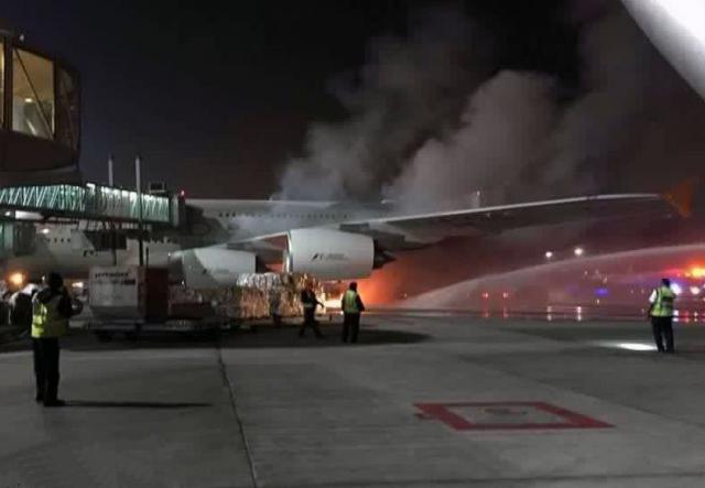 Un engin de piste prend feu à côté d'un avion de Etihad